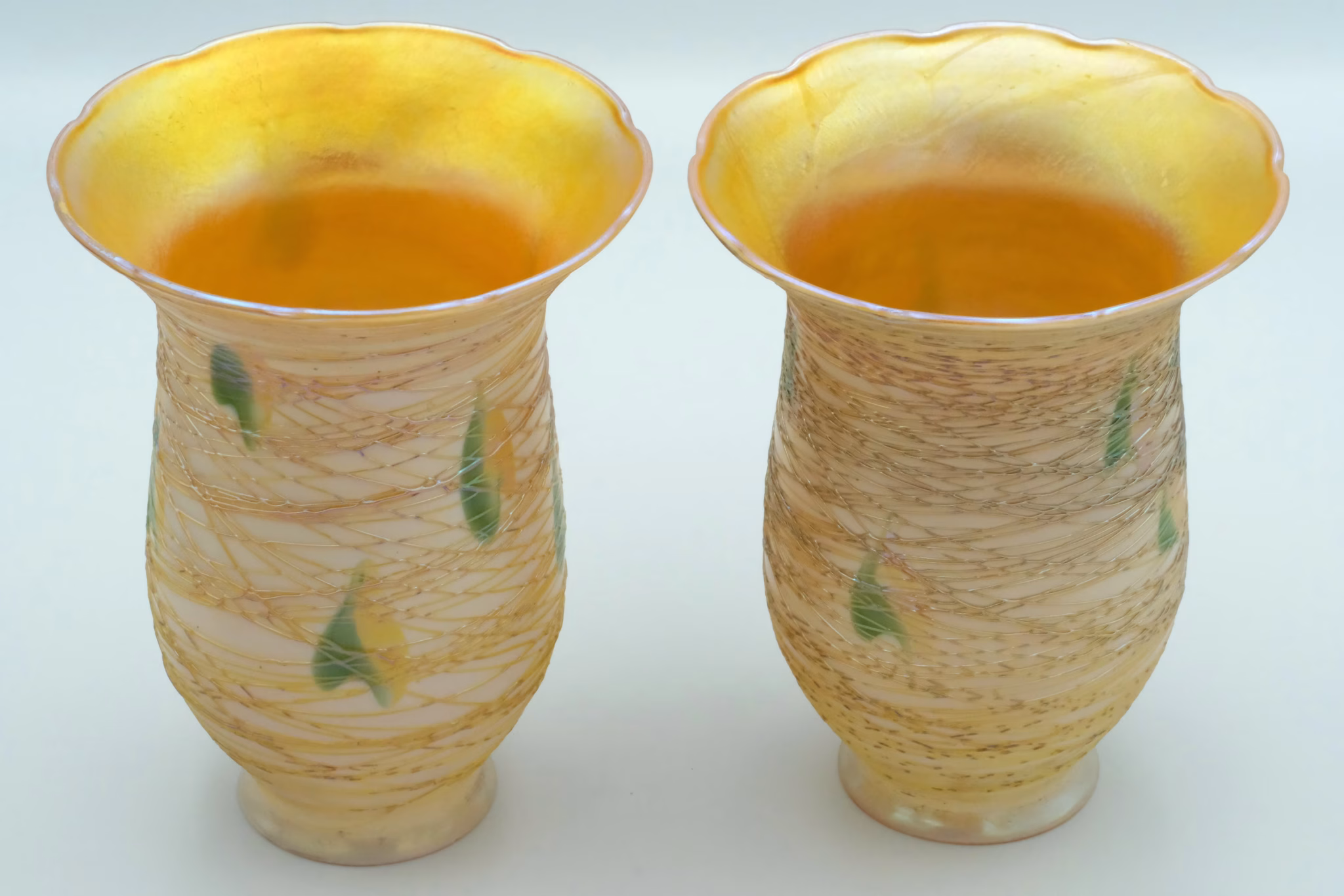 art glass lamp shades with a golden yellow lustre sit in front of a gray background