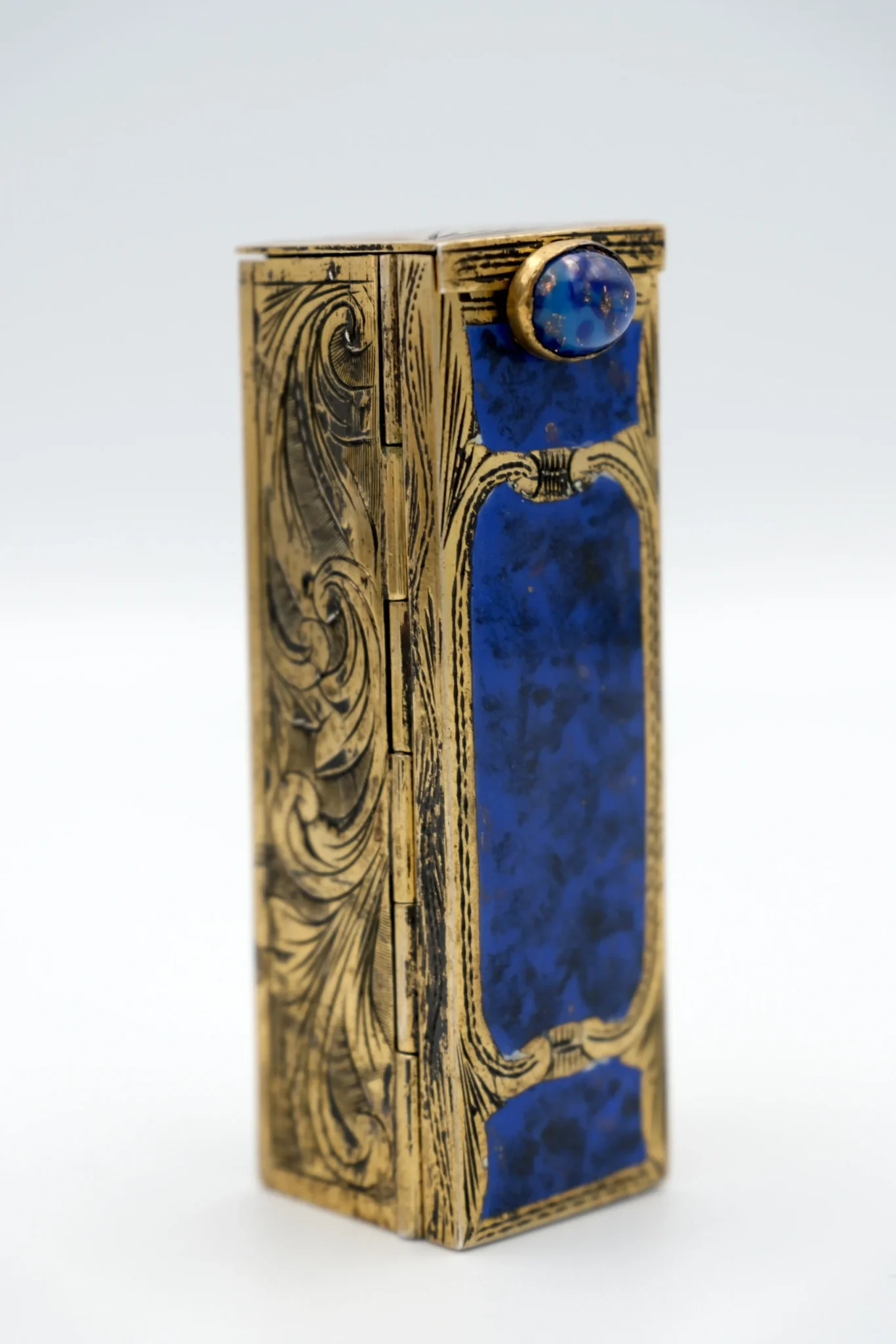 An Italian Lipstick case with mirror silver blue gilloche enamel, standing on end with blue front on gray background